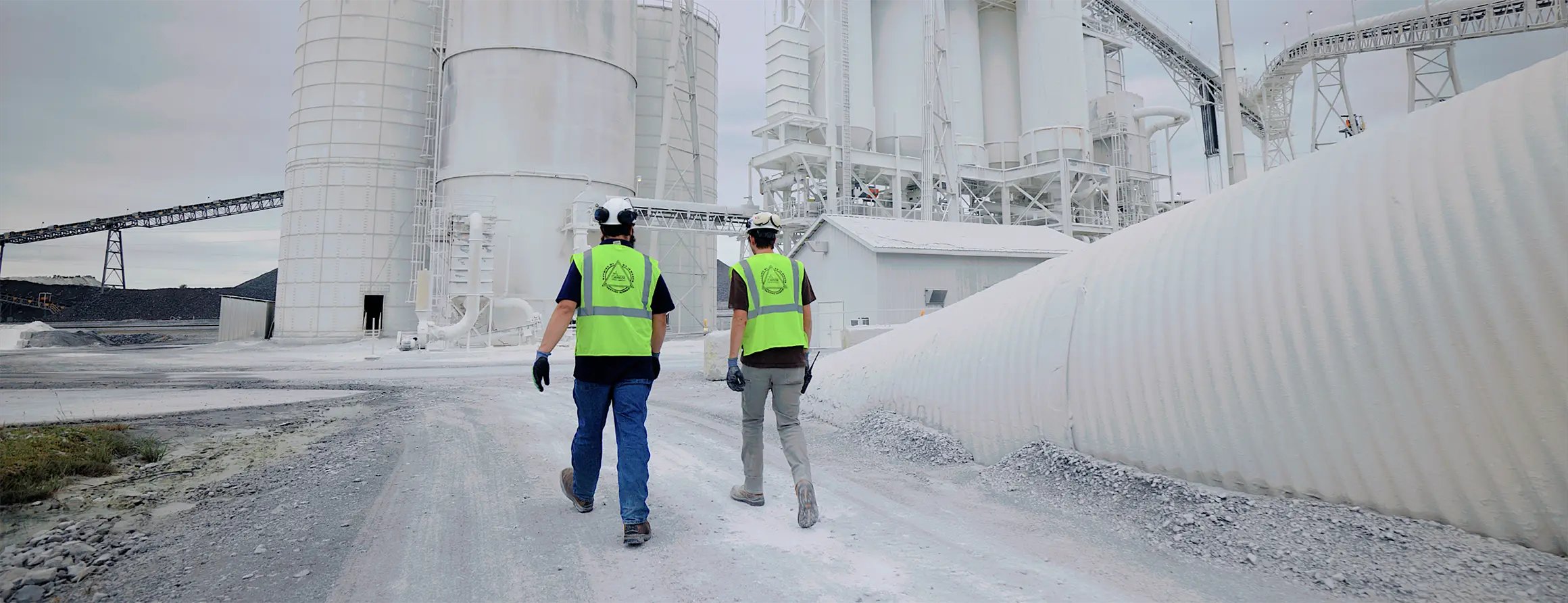 Team members walking up to aggregate plant in the background
